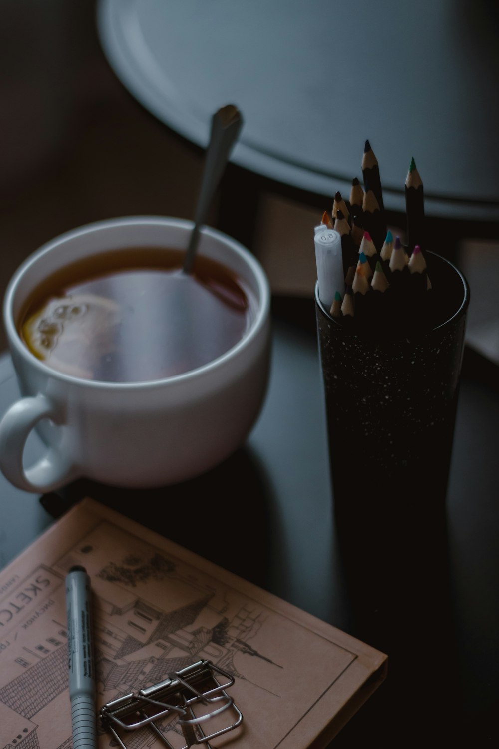 a cup of coffee and a pencil holder on a table