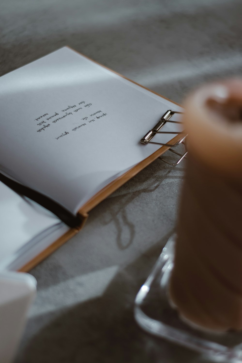 a hand holding a pen and a piece of paper with a note