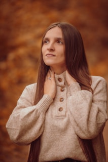 A serene model wearing a cozy sweater against a natural backdrop.