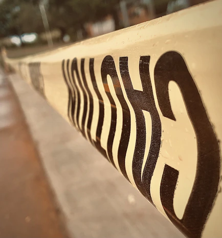 Close-up of a red warning tape with crime scene markers in bold black and yellow colors.