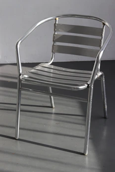 An aluminum lounge chair with clean lines set against a minimalist backdrop.