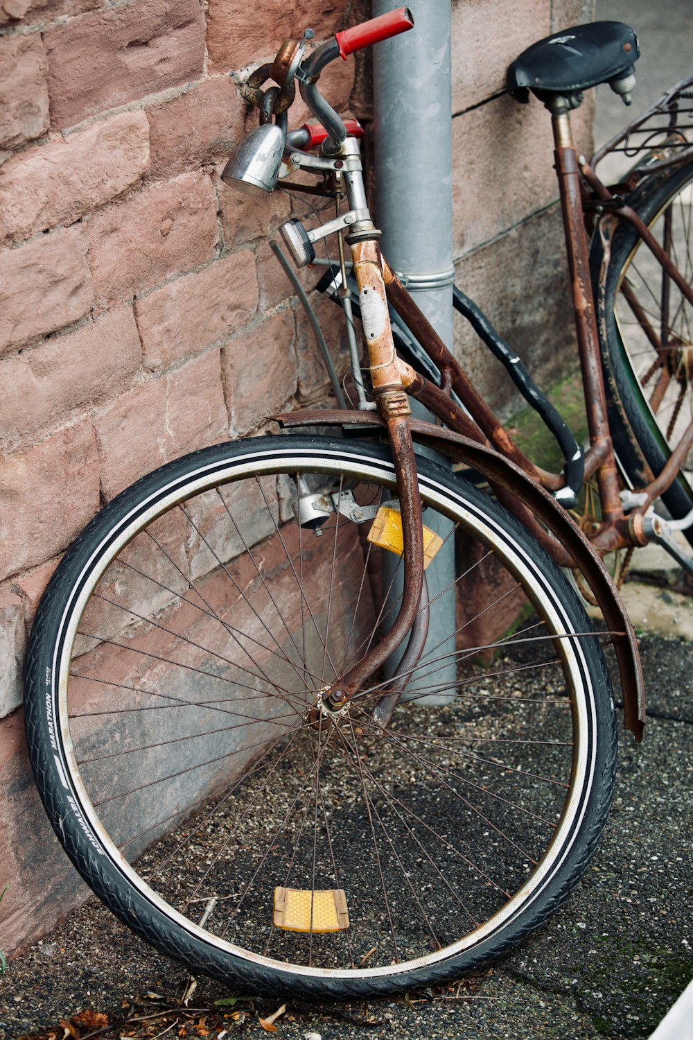 a bicycle leaning against a brick wall