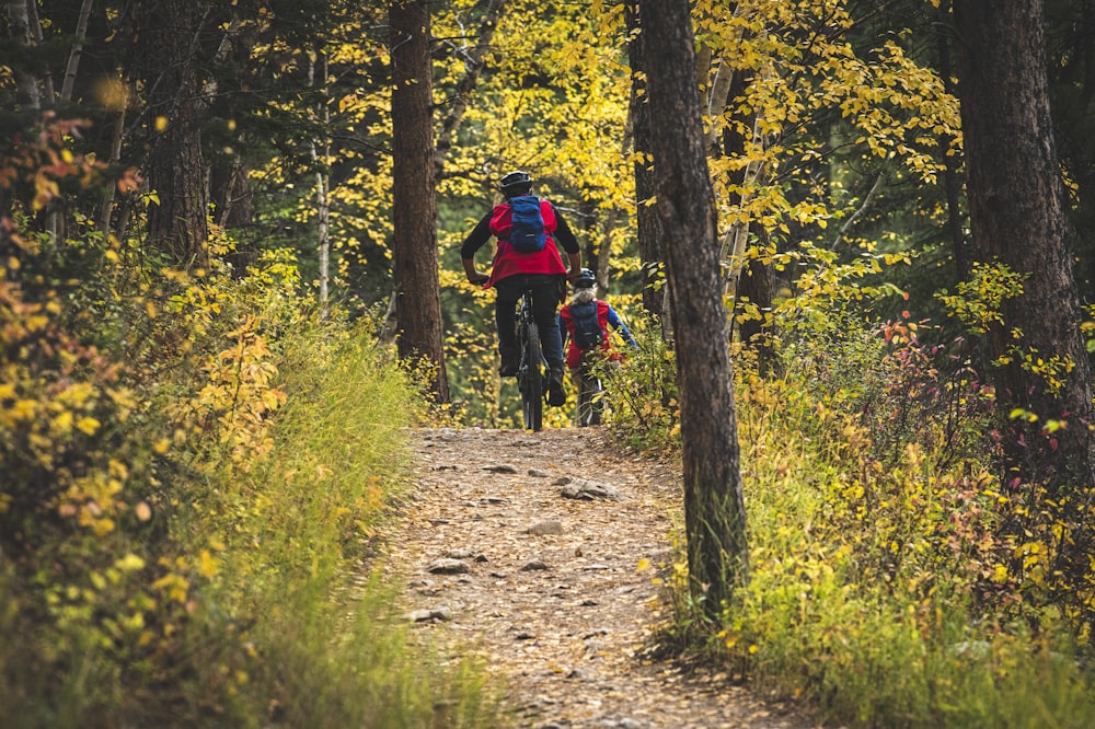 a group of people riding bikes on a trail in the woods