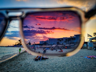 A vibrant behind-the-scenes shot of Regina filming a lively beach club reel at sunset.