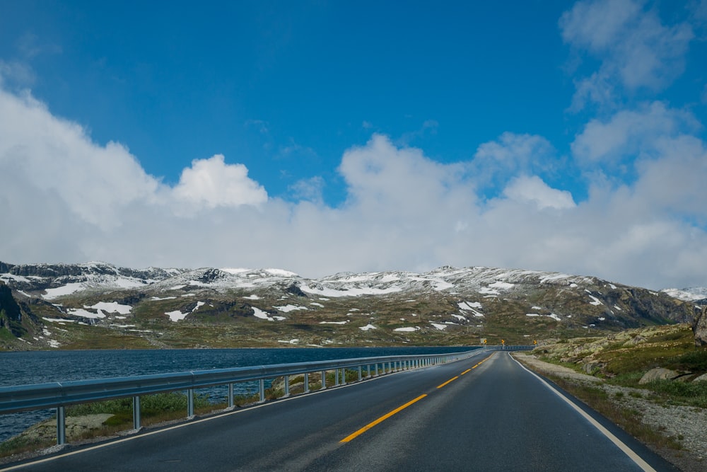 Une route avec une balustrade et des montagnes en arrière-plan