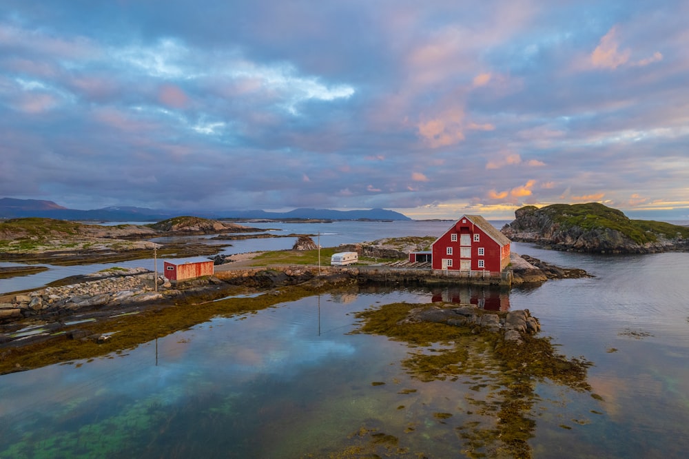 a red house on a rocky shore