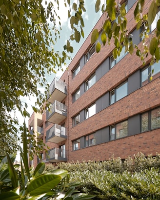 a building with balconies and plants in front of it