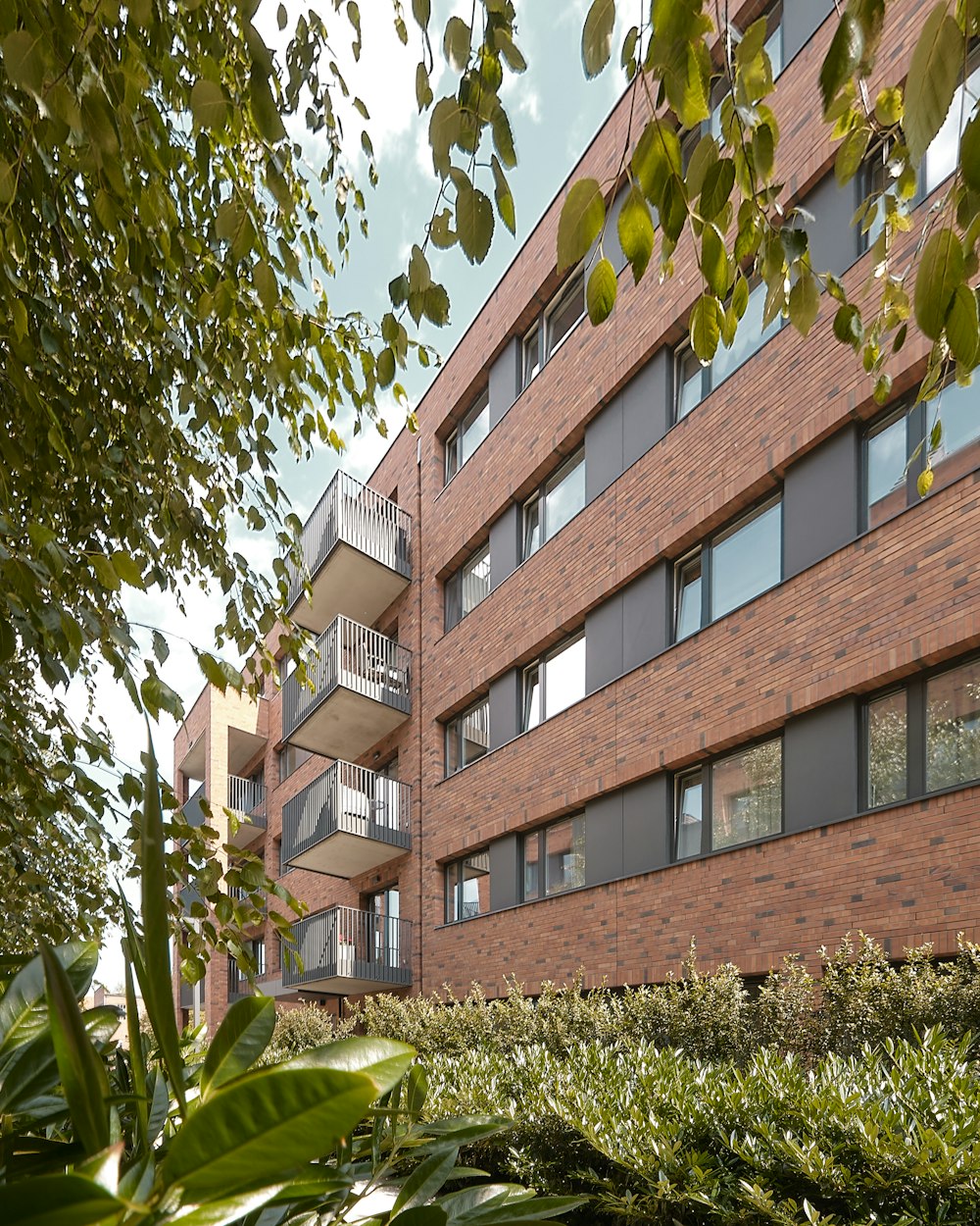 a building with balconies and plants in front of it