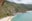 a beach with a hill and a body of water