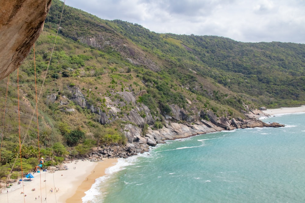 a beach with a hill and a body of water