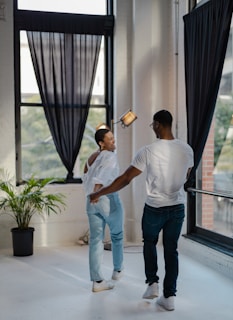 An intimate moment of two people sharing a joyful dance in a cozy, warmly lit room