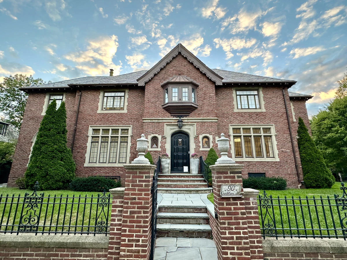 Stately brick Tudor estate with gated entry at dusk at 27 Bellemeade Court