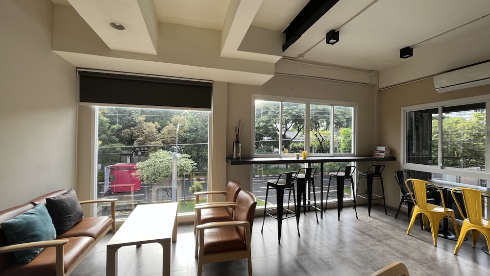 a room with a table chairs and a window with a view of the trees