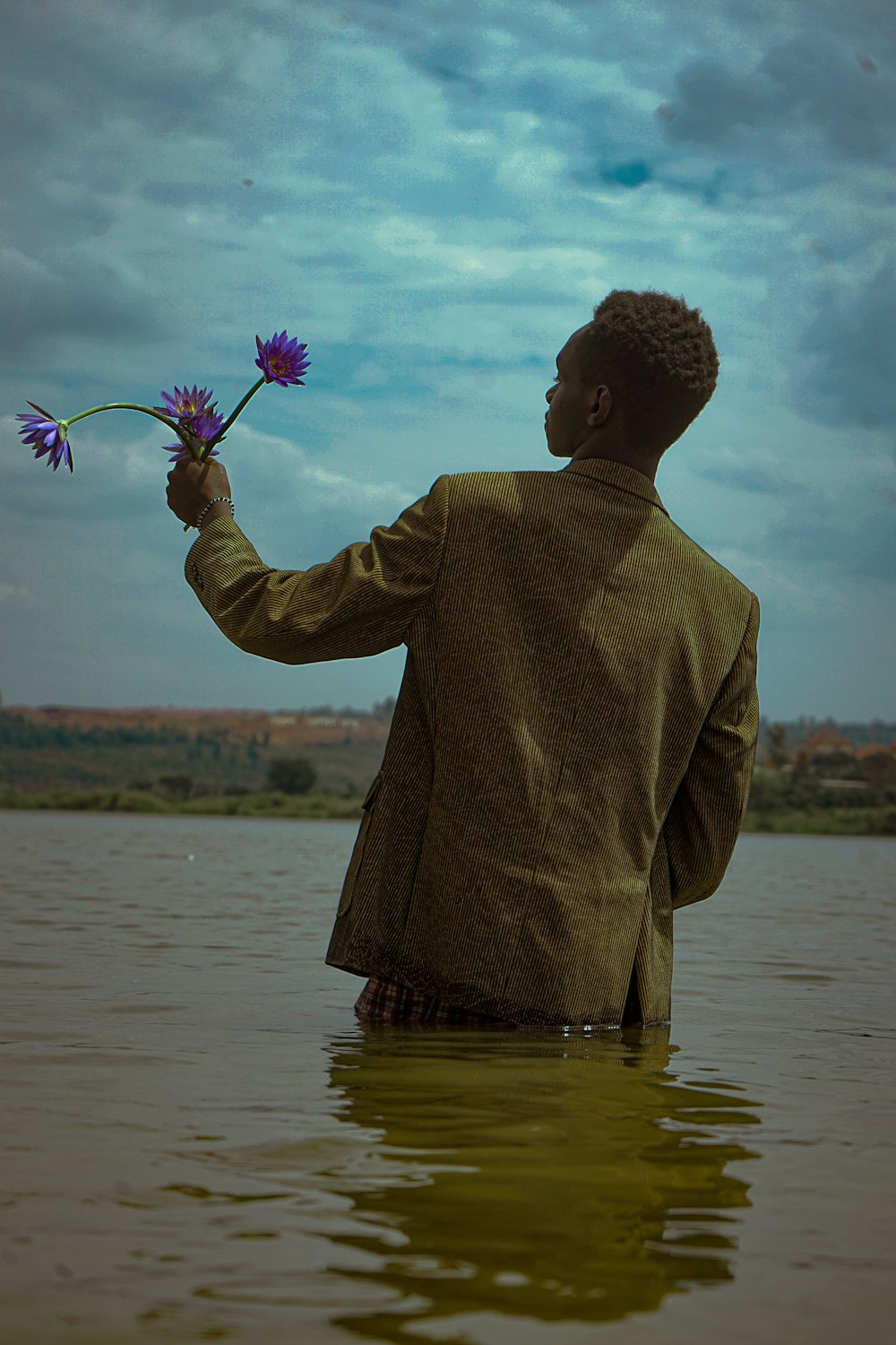 a man holding flowers in a lake