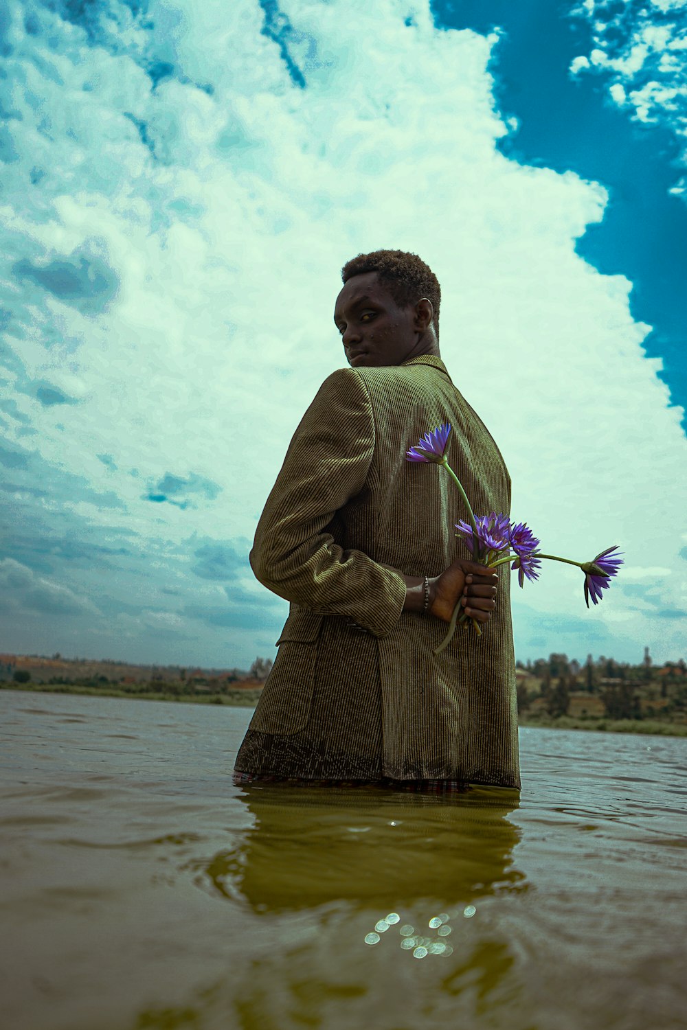 a person holding flowers in a body of water