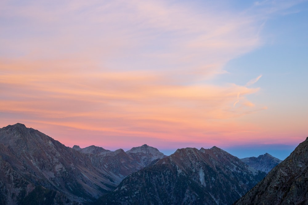 a mountain range with a pink and blue sky