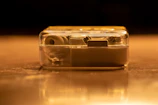 Artistic shot of the earpiece shell reflecting deep black and warm gold tones.