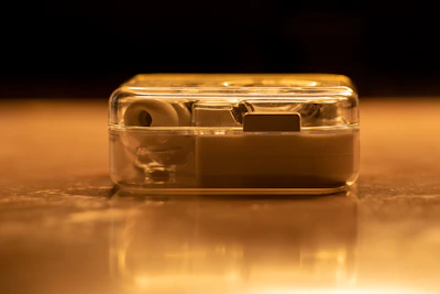 Artistic shot of the earpiece shell reflecting deep black and warm gold tones.