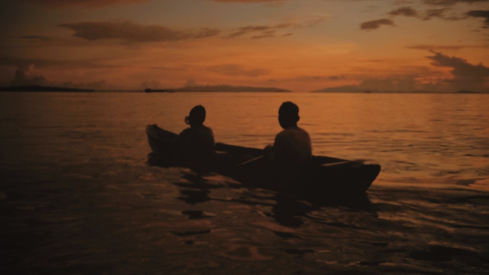 a couple of people sitting in a boat on the water