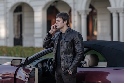 Call center agent speaking on phone with automotive dealership background.