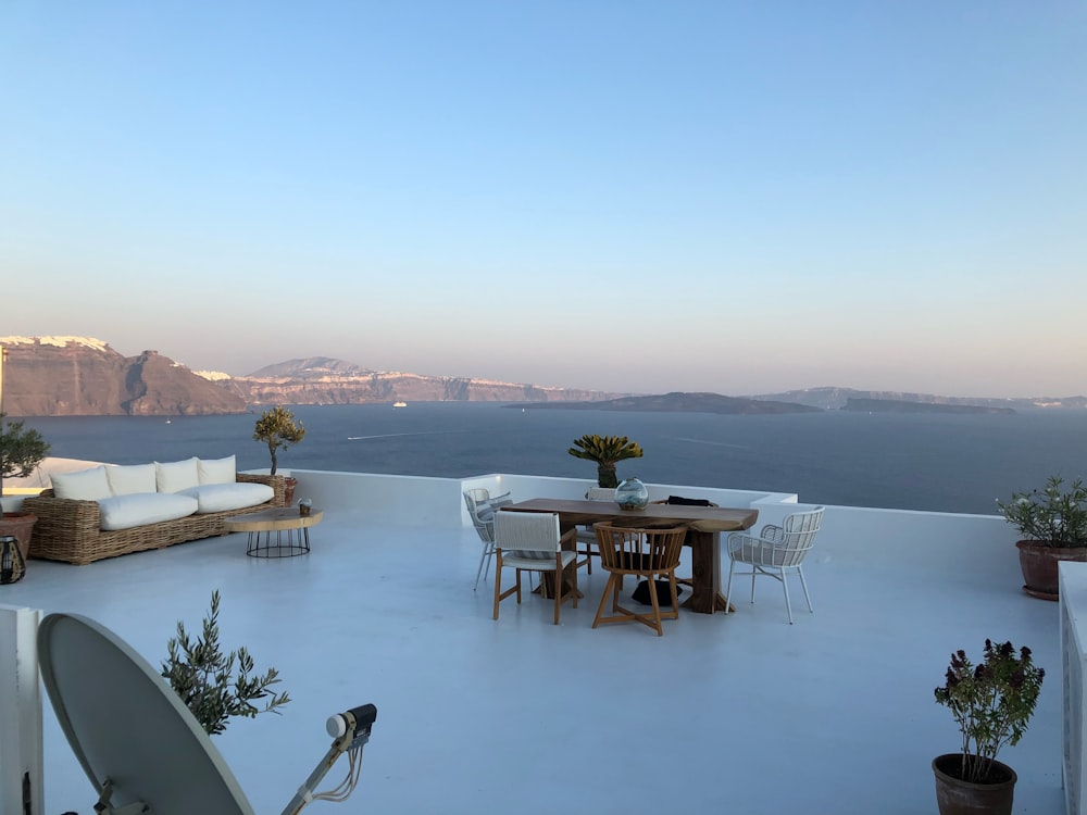 a table and chairs on a patio overlooking a body of water