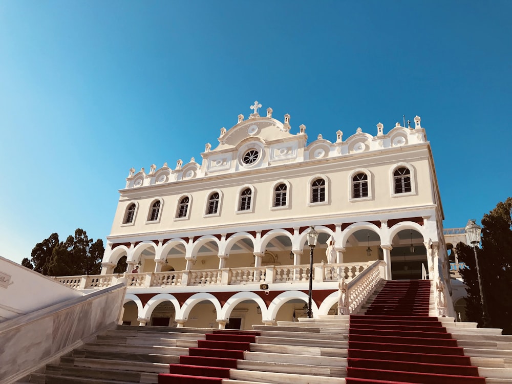 배경에 Tinos가있는 빨간색 계단이있는 커다란 흰색 건물