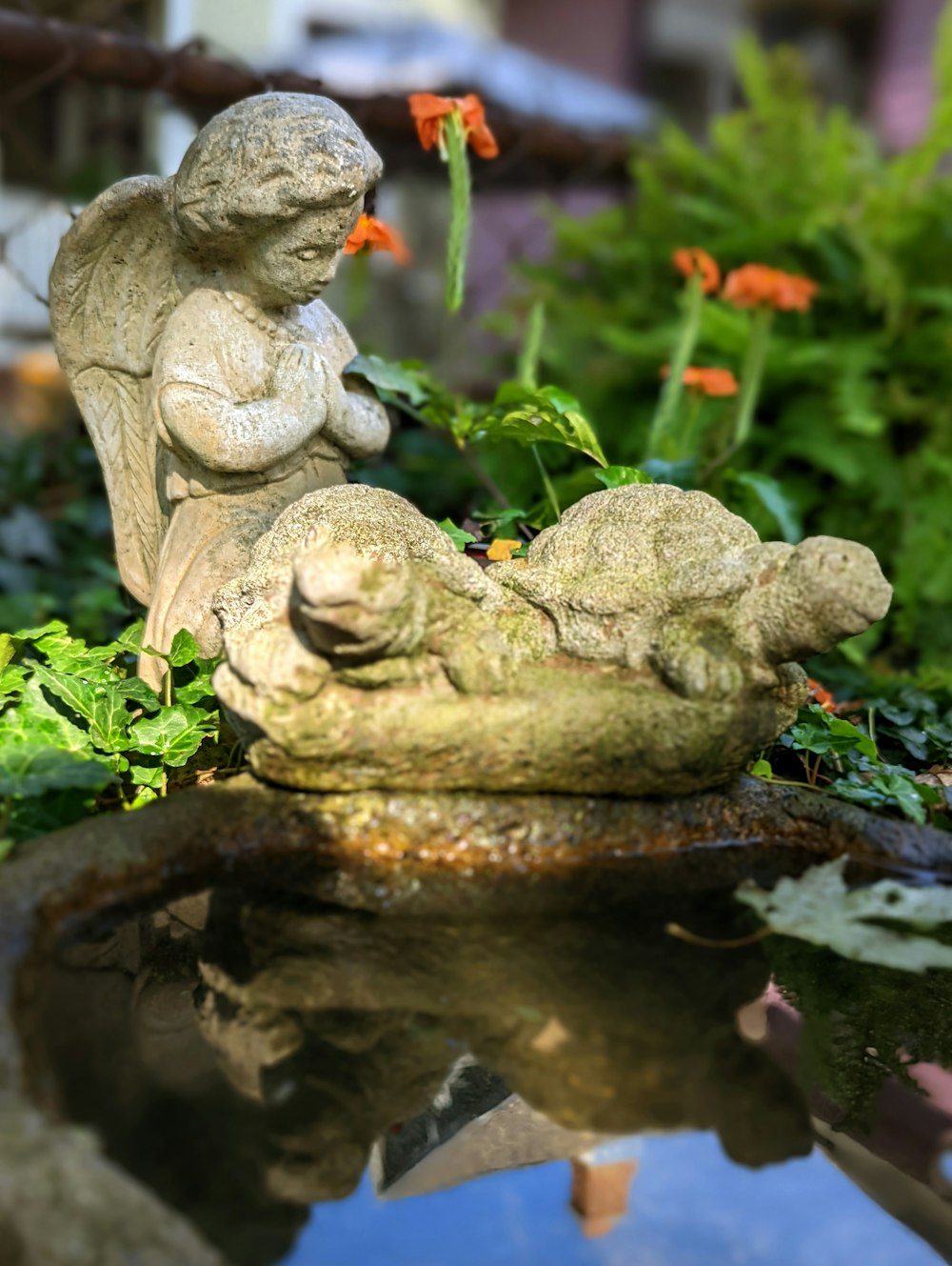 a statue of a person and a baby turtle in a pond