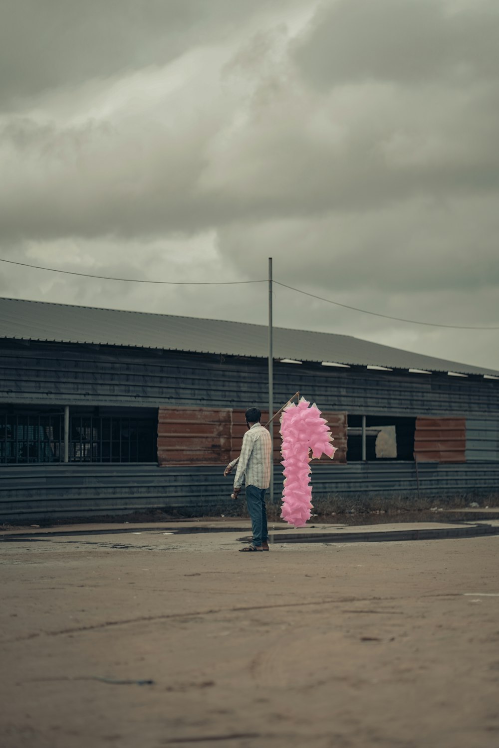 a person standing next to a large pink object