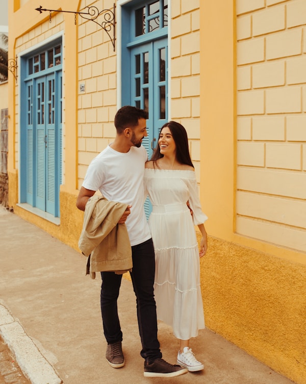 a man and woman standing next to each other and smiling