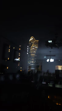 Cinematic night view from a penthouse suite overlooking city lights with subtle gold accents.