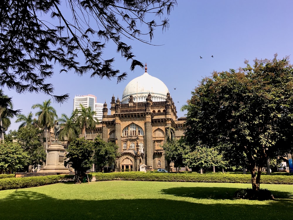 a large building with a dome and trees in front of it with Chhatrapati Shivaji Maharaj Vastu Sangrahalaya in the background