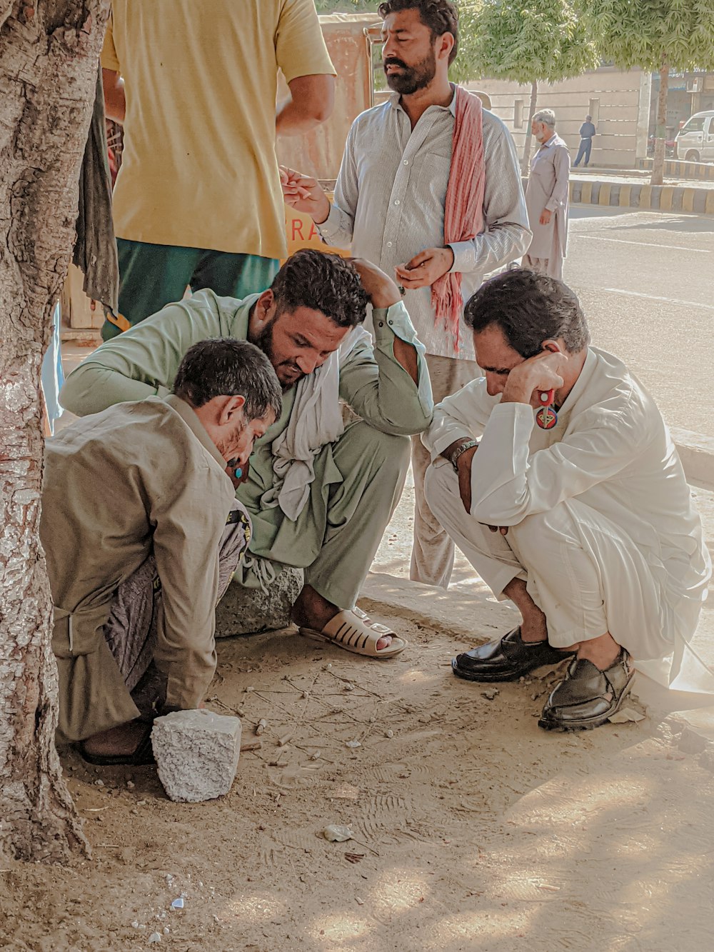 a group of men kneeling next to a tree