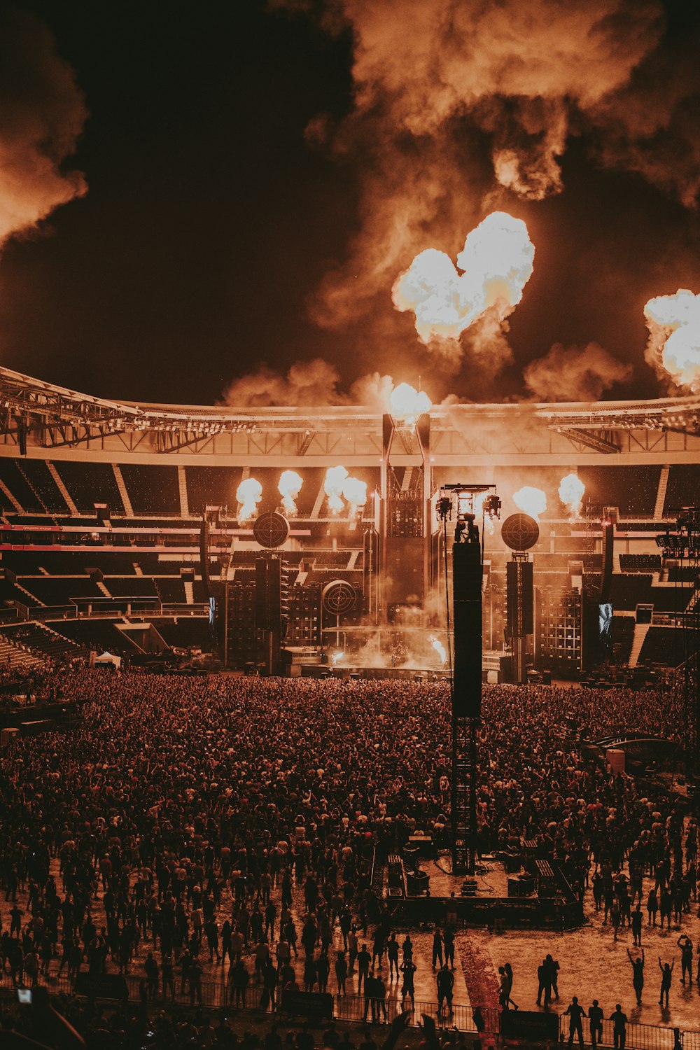 a large crowd of people in front of a large building with smoke coming out of it