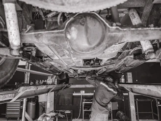 Workshop scene showing skilled technicians repairing a military vehicle in a modern garage.