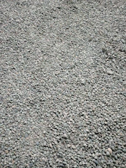 Close-up of pea gravel spread evenly across a newly landscaped patio area.