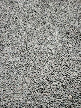 Close-up of pea gravel spread evenly across a newly landscaped patio area.