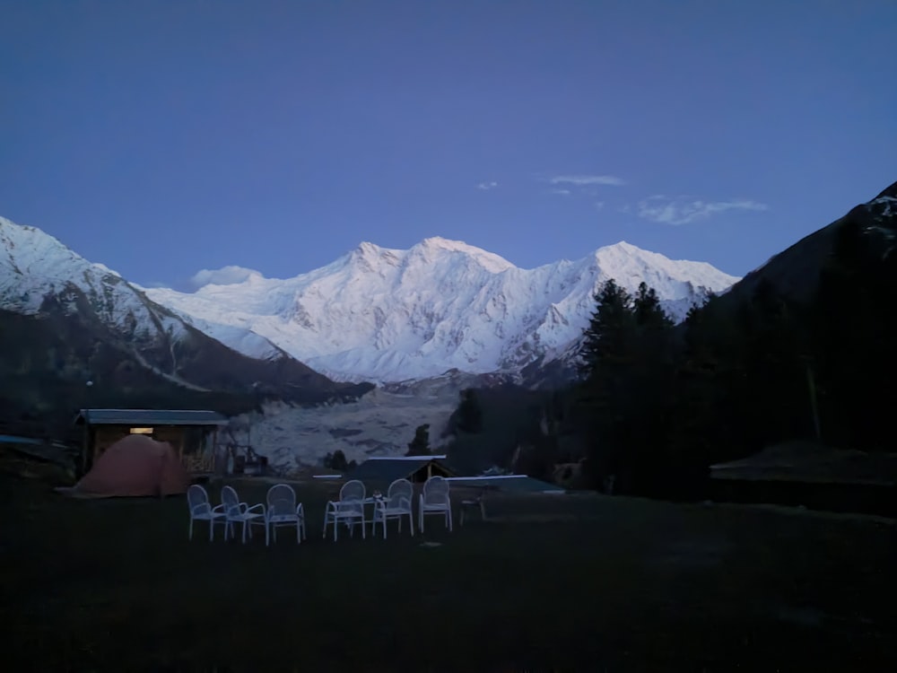 a table and chairs outside with mountains in the back