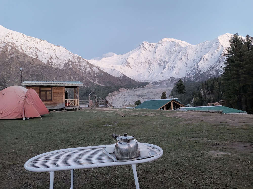 a table with a kettle on it in front of a mountain range