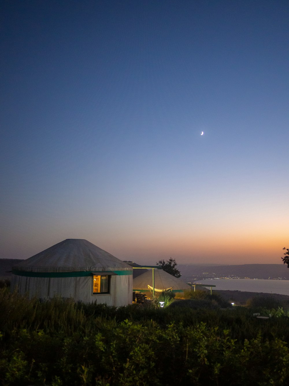 a house with a green roof and a body of water in the background