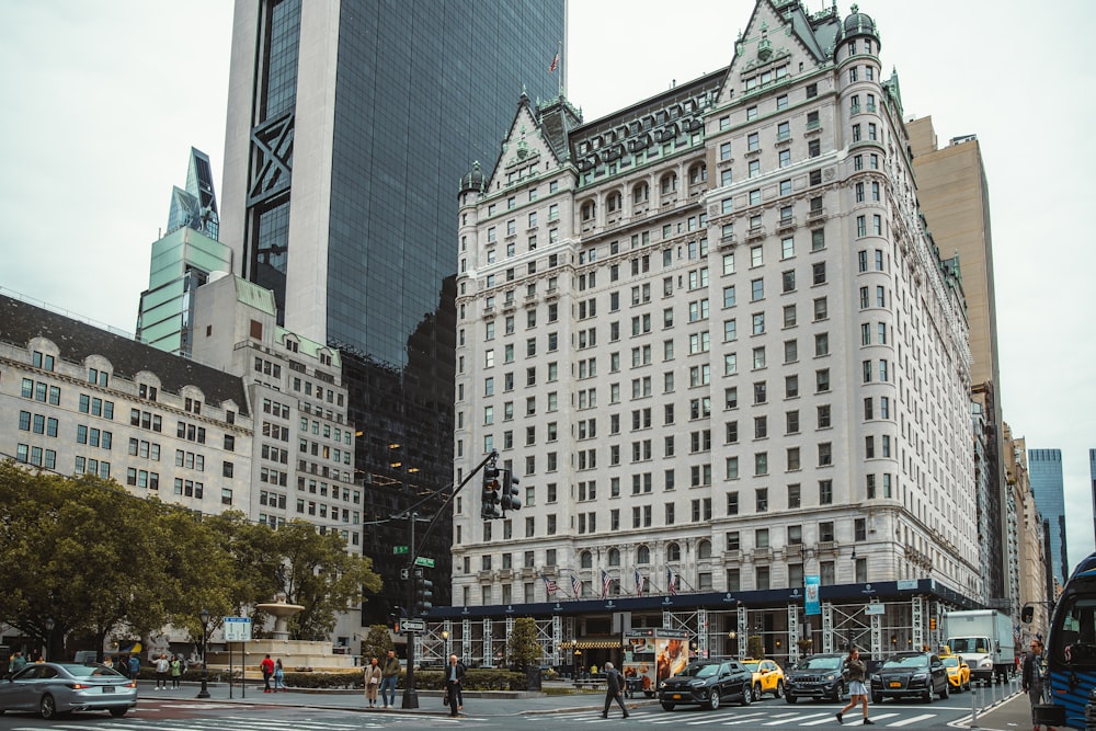 a street with cars and buildings along it with Plaza Hotel in the background