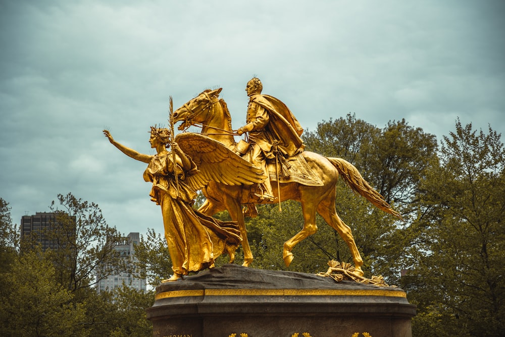 a statue of a man and a woman riding horses