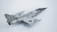 A model aircraft with a sleek, metallic design, featuring jet engines and distinctive military markings. The aircraft has dual wings and pointed nose with noticeable detail in its construction. The backdrop is a plain, light-colored surface that highlights the aircraft's shiny surface.