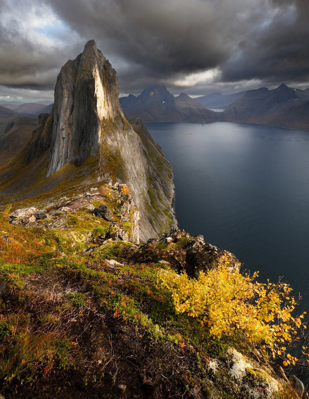 a rocky cliff with a body of water below