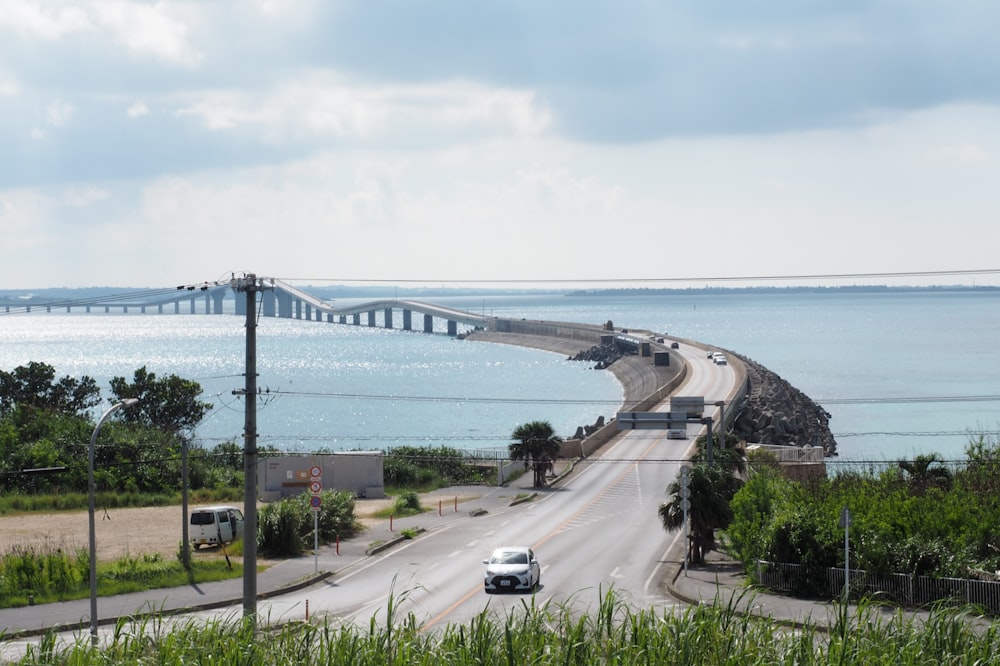 a road with cars on it by a body of water