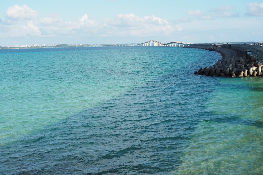 a body of water with a bridge in the distance
