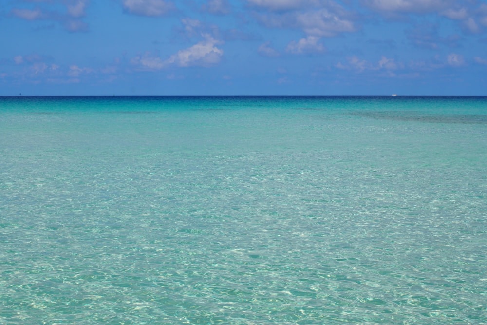 a body of water with blue sky and clouds