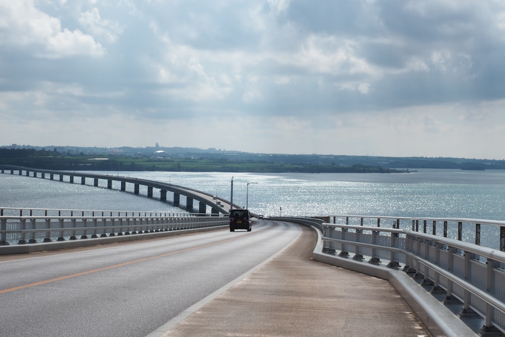 um carro dirigindo em uma ponte sobre a água