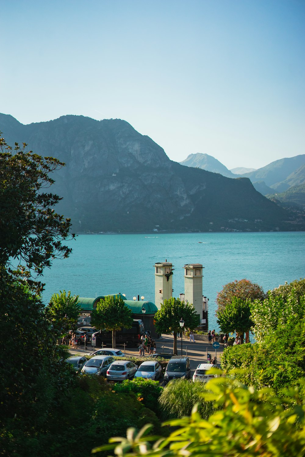 a body of water with cars parked along it and a large stone structure