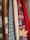 A collection of knitted sweaters in various textures and patterns, with earthy and autumnal colors. There is a maple leaf tucked into one of the sweaters, adding to the autumnal theme.