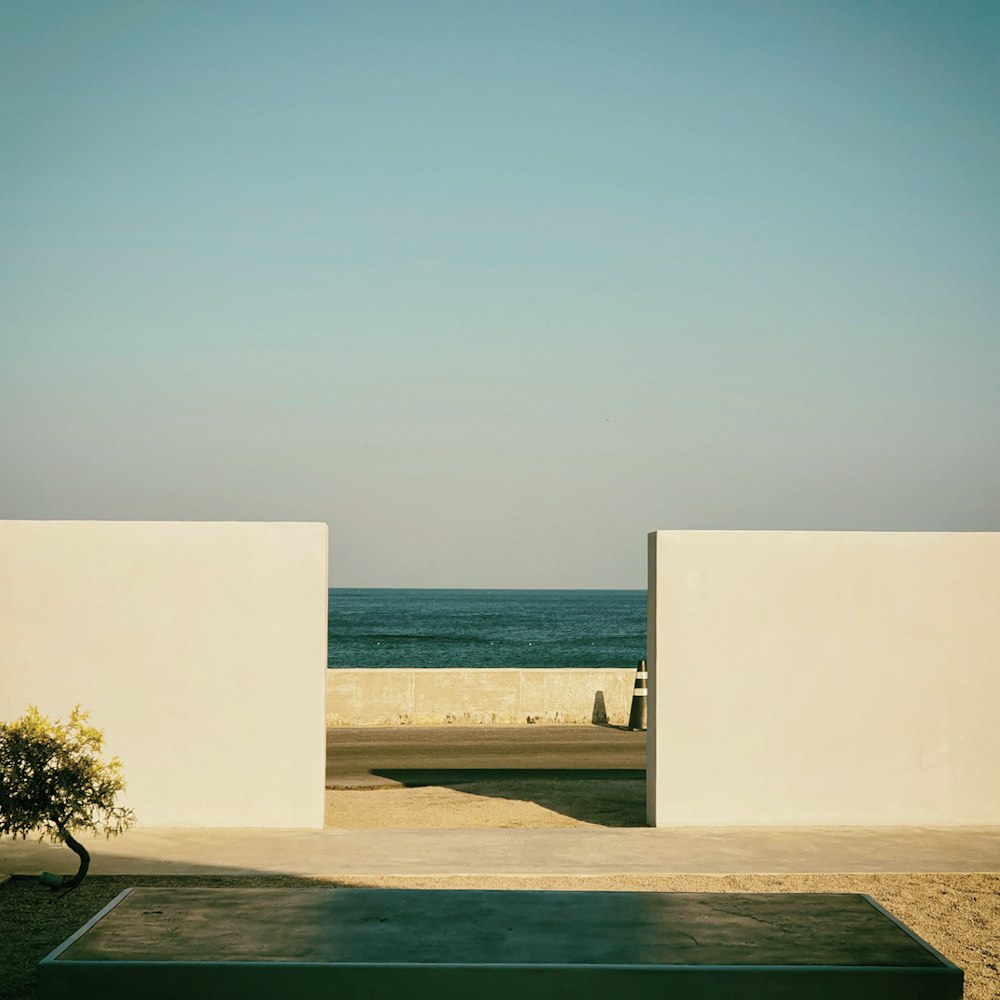 a couple of white buildings with a body of water in the background